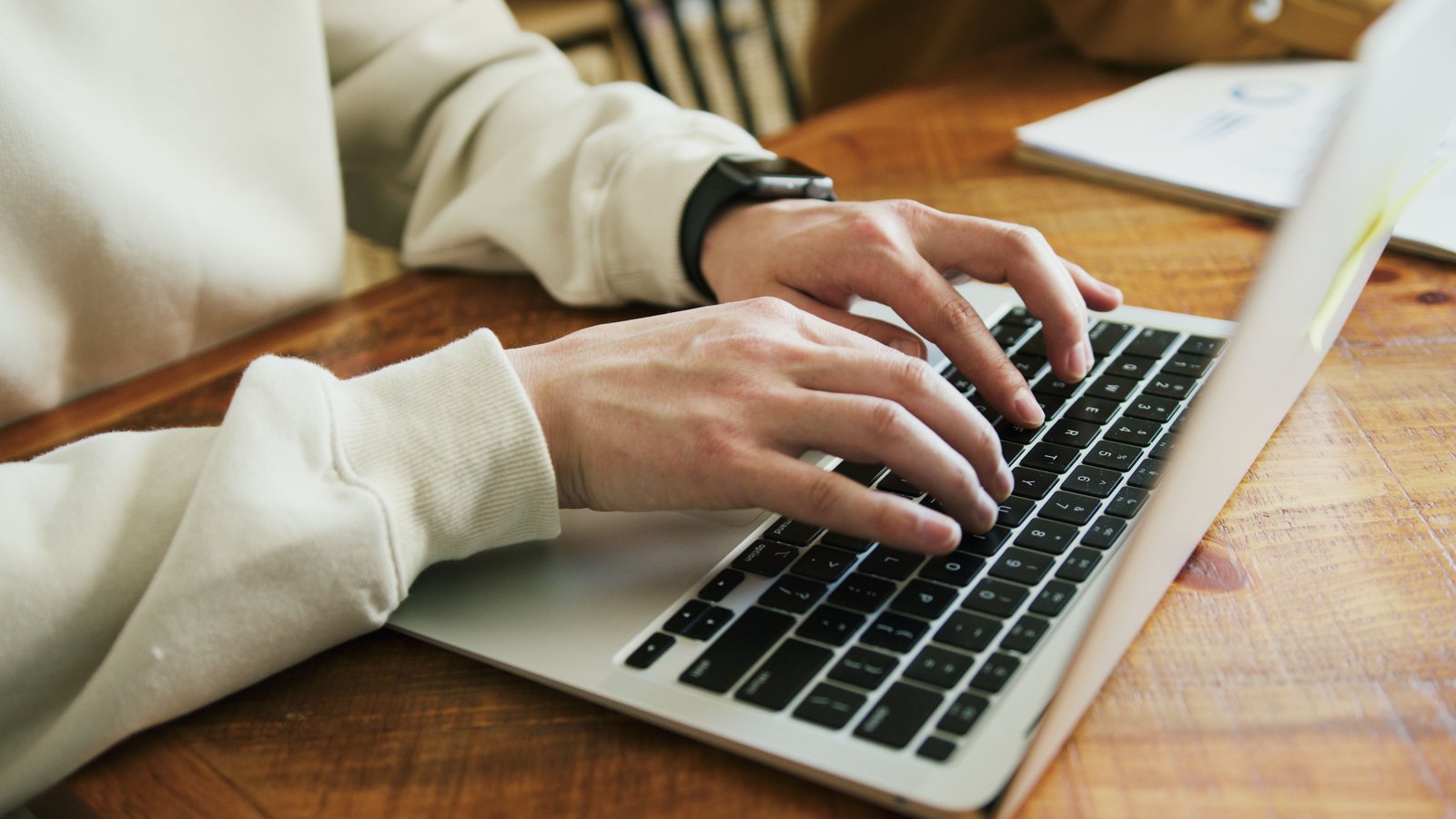 Professional writing reusable AI prompts on a laptop