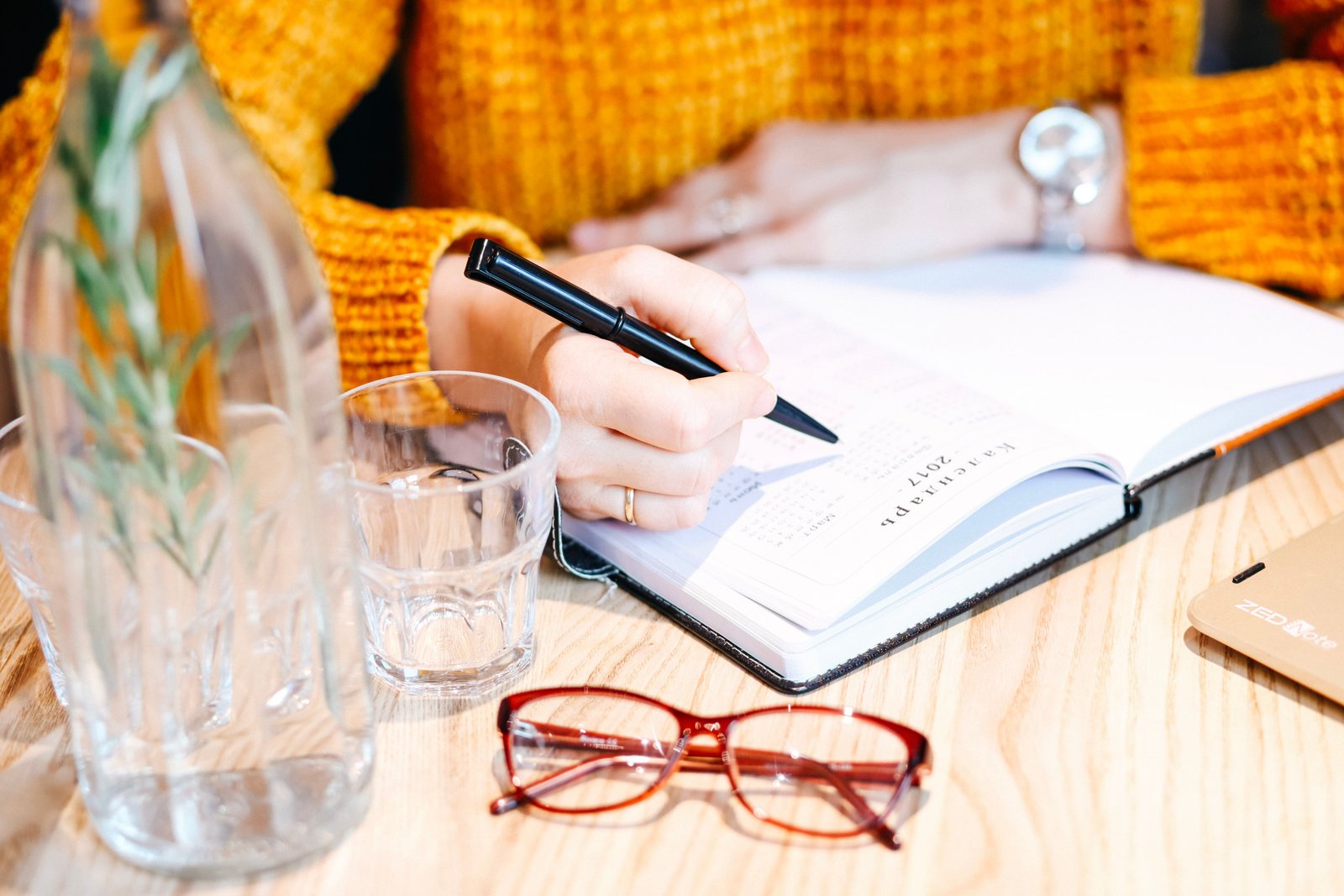 Student using digital and handwritten notes while studying on a laptop